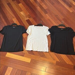 Women large Amazon tops in white and black. One top has a wider neckline.